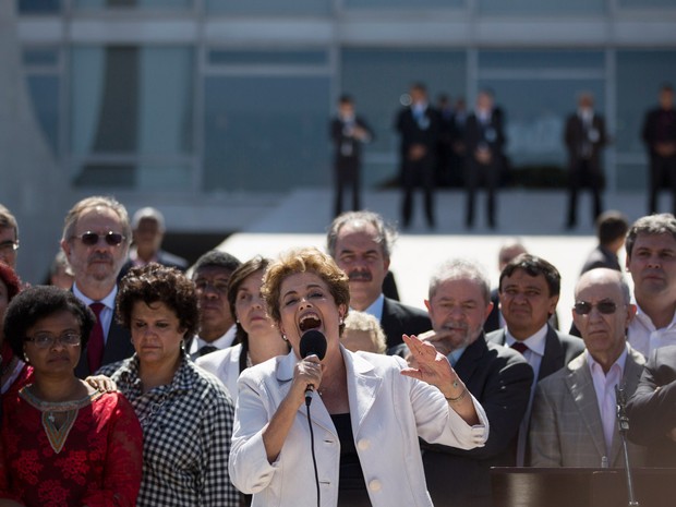 Dilma ao lado de Lula e de outros apoiadores durante sua saída do Palácio do Planalto, em Brasília (Foto: Felipe Dana/AP)